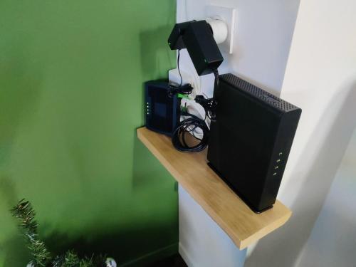 a television sitting on a shelf on a wall at Appartement T2 "JUNGLE" Centre Ville de VITRÉ au calme coté cour in Vitré