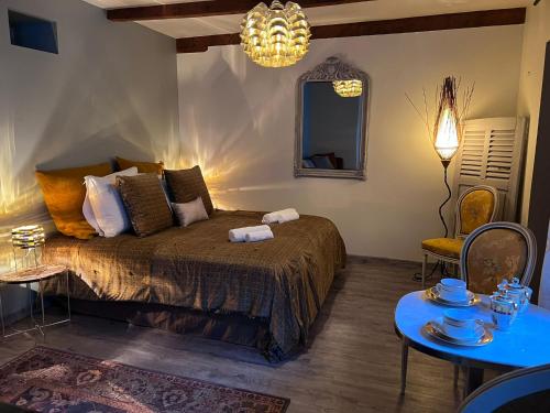 a bedroom with a bed and a table and a mirror at Les Maisons d'Augustine, nouvelle demeure de la cour Ste Catherine in Honfleur