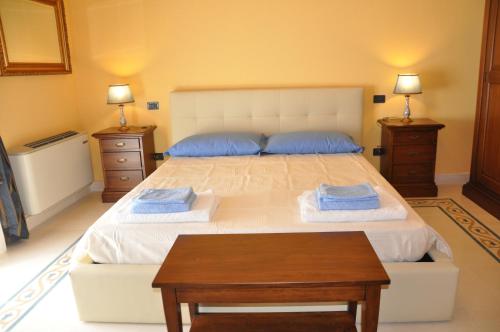 a bedroom with a large bed with blue pillows at Il Casale dei Conti in Barcellona-Pozzo di Gotto