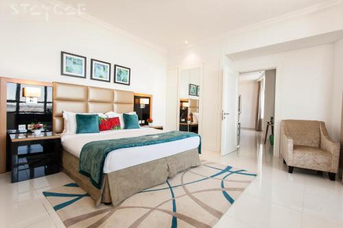 a bedroom with a large bed and a chair at Staycae Holiday Homes - Capital Bay in Dubai
