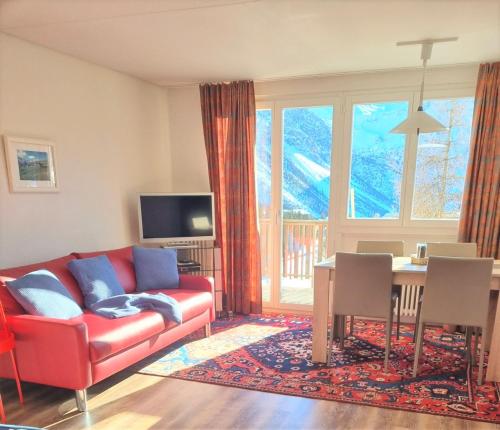 a living room with a red couch and a table at Bisang P in Arosa