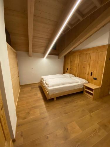 a large bedroom with a bed and a wooden floor at B&B el Benel in Ossana