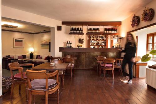 メツォヴォにあるKatogi Averoff Hotel & Wineryのテーブルと椅子のレストランに立つ女性