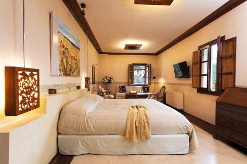 a bedroom with a large white bed and a desk at Katogi Averoff Hotel & Winery in Metsovo