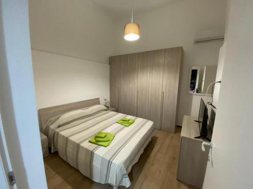 een slaapkamer met een bed met groene handdoeken erop bij Al civico 6 in Ispica
