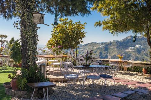 a patio with tables and chairs and a view of the ocean at Seclude Mussoorie in Mussoorie
