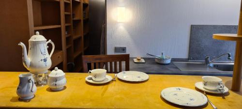 a table with a tea pot and cups and saucers at Ferienwohnung Hedfan im Cnauceltaidd in Halle
