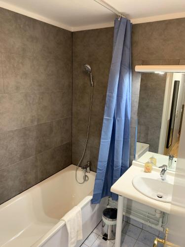 une salle de bain avec une baignoire blanche et un lavabo dans l'établissement Disney, very nice 2 bedrooms family apartment, wifi, NETFLIX 8 pers, à Chessy