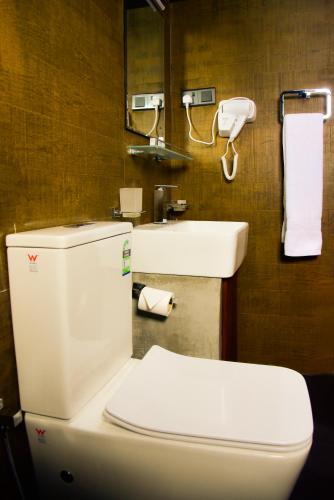 a bathroom with a white toilet and a sink at Pine Hill Residence in Kandy