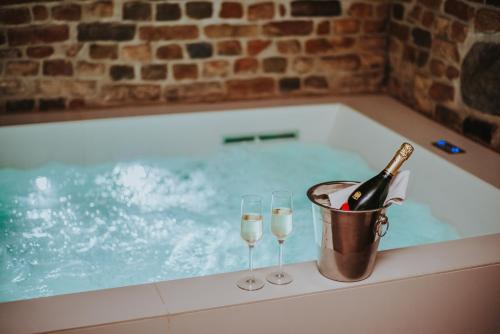 a tub with two glasses of wine and a bottle of champagne at Hotel Nicolaus in Toruń
