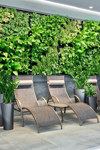 a row of chairs in front of a wall with plants at ever grün KAPRUN in Kaprun