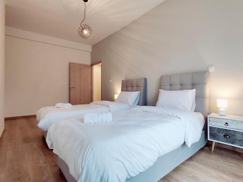 two beds in a bedroom with white sheets at WSD Muse Apartment Hotel in Athens