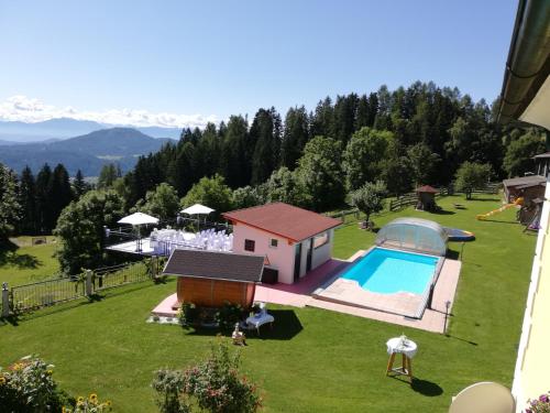 an aerial view of a backyard with a swimming pool at ERLEBNISBAUERNHOF Steinerhof in Kärnten in Liebenfels