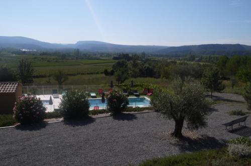 Elle offre une vue sur une cour avec une piscine et des arbres. dans l'établissement Les Oliviers, à Vallon-Pont-dʼArc