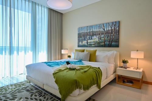a bedroom with a bed with a green blanket on it at Springfield Suites in Seef