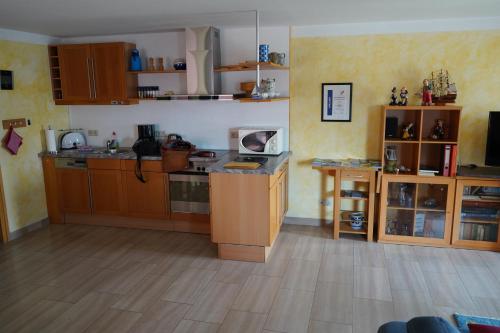 a kitchen with wooden cabinets and a wooden floor at Ferienwohnung Reinersmann in Waren