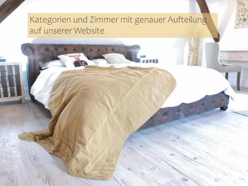 a bed with a blanket on it in a bedroom at LANDHOTEL 1707 by Landgasthof Zickler in Gleisweiler