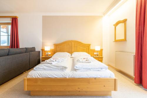 a bedroom with a bed and a couch at Apparthaus Sonnenberg in Haus im Ennstal