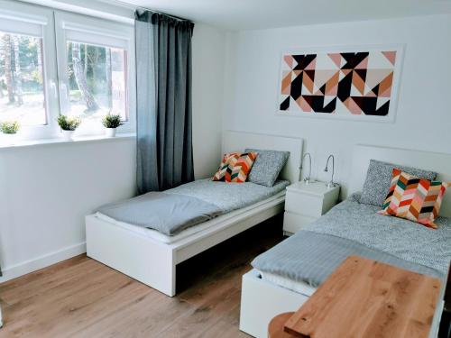 1 dormitorio con 2 camas y mesa en APARTAMENT Olaf, en Baryczka