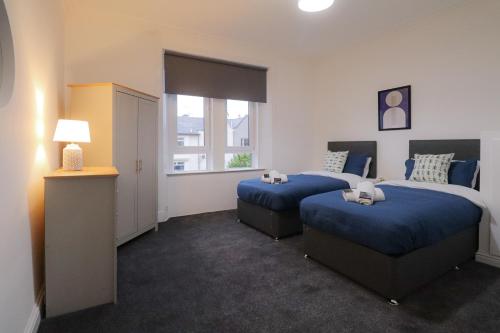 um quarto de hotel com duas camas e uma janela em Troon Golf Apartment em Troon