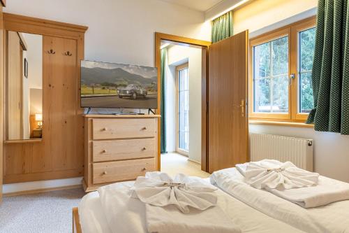 a bedroom with two beds and a dresser and windows at Apparthaus Sonnenberg in Haus im Ennstal