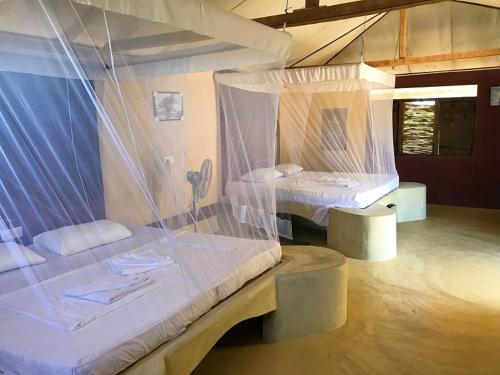 two beds in a room with nets around them at MKS - Kite & Wing Foil camp in Kalpitiya
