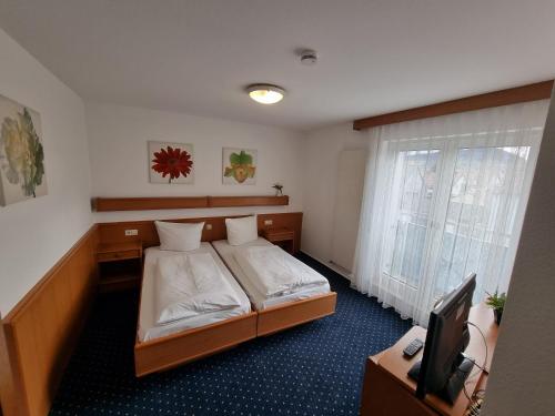 InTeck Hotel في Dettingen unter Teck: غرفة نوم فيها سرير وتلفزيون