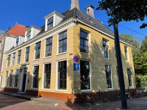 a yellow building on the corner of a street at De Olde Signorie in Leeuwarden