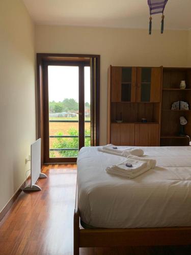 a bedroom with a bed and a window and a computer at Moradia próxima da praia do Areinho, na Ria, e praia dos Marretas in Ovar