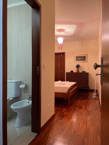a bathroom with a toilet and a bed in a room at Moradia próxima da praia do Areinho, na Ria, e praia dos Marretas in Ovar