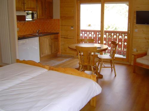 une chambre avec un lit et une table et une cuisine dans l'établissement Hotel Les Chalets, à Brides-les-Bains