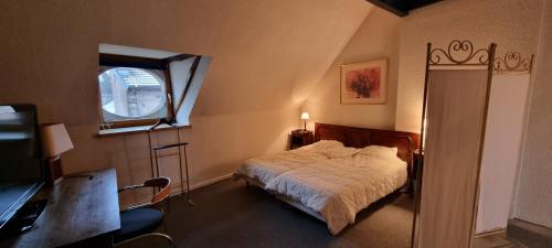 a bedroom with a bed and a desk and a window at hebergement-luxeuil-les-bains in Luxeuil-les-Bains