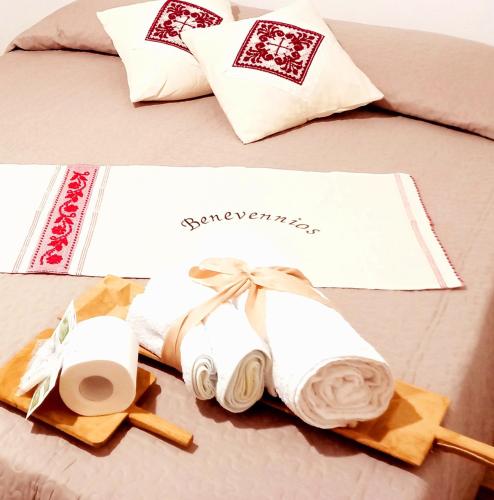 a bed with towels and a couple of rolls of paper at B&B Santu Giuvanni "Un tuffo nel passato Fonnese" in Fonni