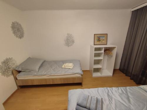 a small bedroom with a bed and a shelf at Apartament Kwatera Oficera in Sandomierz