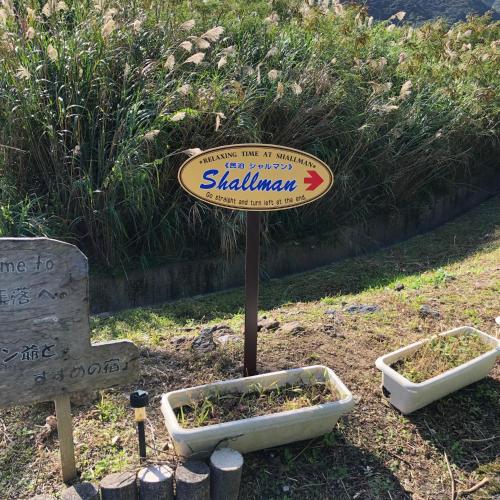 a sign for a garden with two plants at Guest in Shallman in Amami