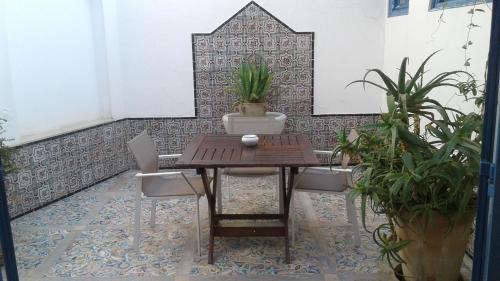 a table and chairs in a room with plants at La Villa Bleue-Sidi Bou Said in Sidi Bou Saïd