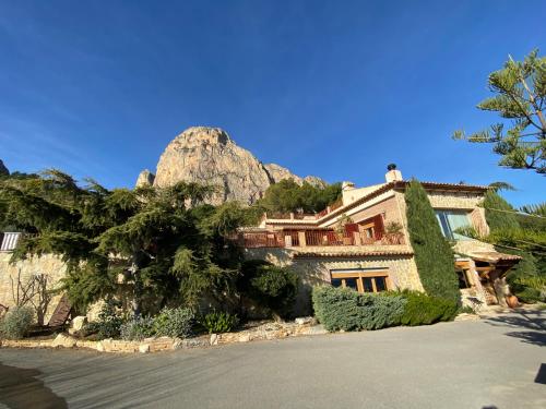 una casa con una montagna sullo sfondo di Casa El Flare a Polop