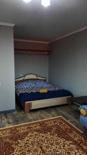 1 dormitorio con 1 cama en una habitación con alfombra en Уютные апартаменты в историческом центре en Aktobe