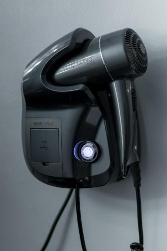 a hair dryer with a microphone on a wall at Mert Boutique Hotel in Korçë