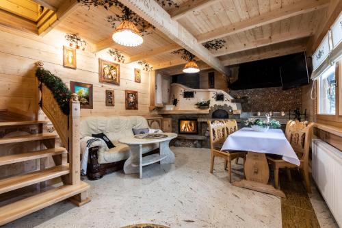 a living room with a table and a fireplace at udanypobyt Domki Przy Potoku in Zakopane