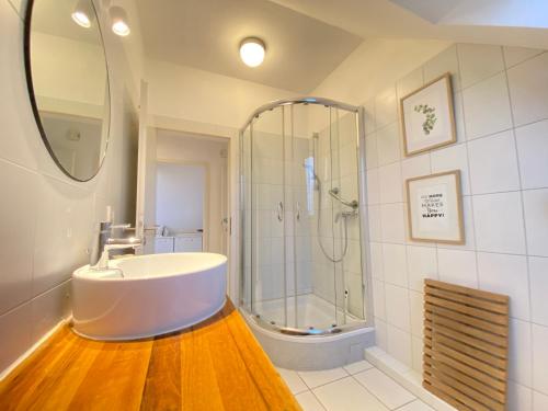 a bathroom with a white sink and a shower at Kieler FeWo No.1 in Kiel
