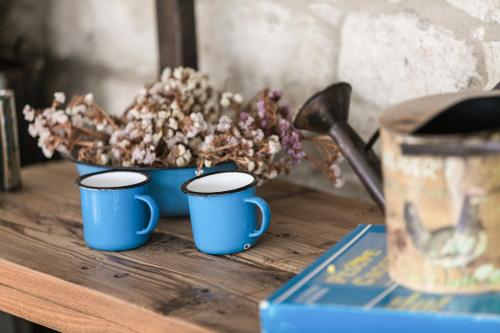 three blue cups on a table with a bowl of flowers at LuCe Design Hotel - Special Category in Alacati