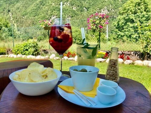 - une table avec une assiette de nourriture et un verre de vin dans l'établissement Garni Le Prealpi, à Ledro