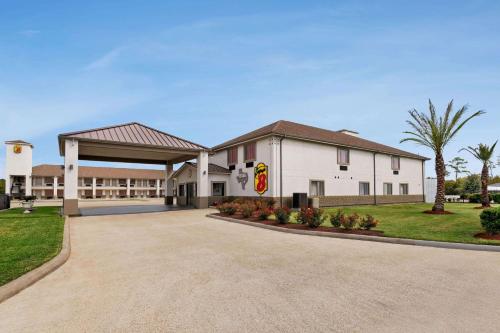 a large white building with a parking lot at Super 8 by Wyndham Houston Downtown I-610 in Houston