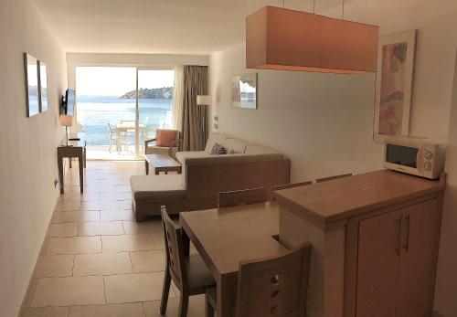 a kitchen and living room with a couch and a table at Aparthotel Ponent Mar in Palmanova