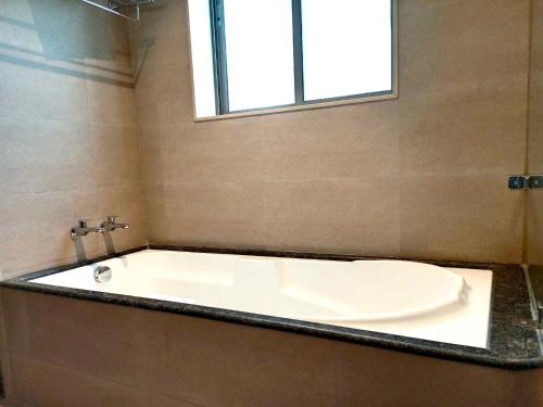 y baño con bañera y ventana. en Advait Resort Kshetra Mahabaleshwar, en Mahabaleshwar