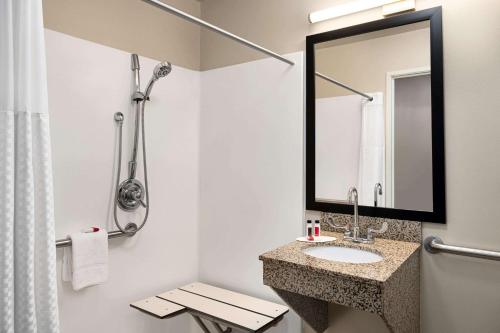 a bathroom with a sink and a mirror at Baymont by Wyndham Buffalo in Buffalo