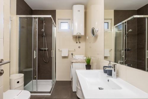 y baño con lavabo blanco y ducha. en Apartment Mara Opatija with rooftop swimming pool en Ičići