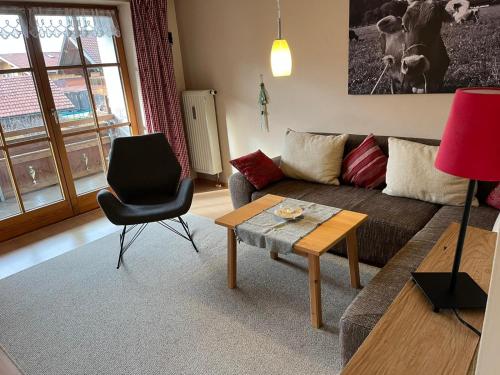 a living room with a couch and a table and a chair at Allgäu-Moni Trauchgau in Halblech