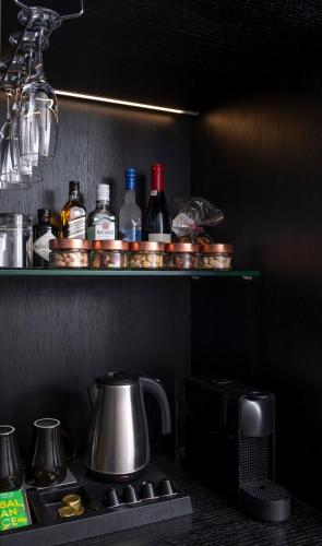 a kitchen with a stove and a shelf with bottles at No 15 Ermou Hotel in Thessaloniki